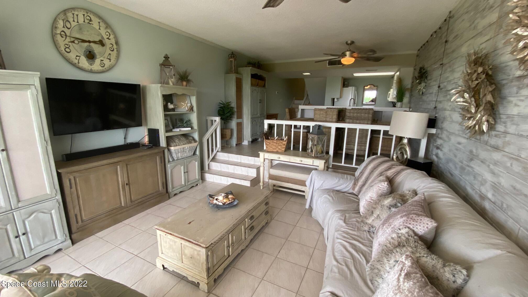 5050 Ocean Beach Boulevard, Unit 104 Cocoa Beach, FL 32931 - Photo 6 of 15 a living room with furniture and a flat screen tv