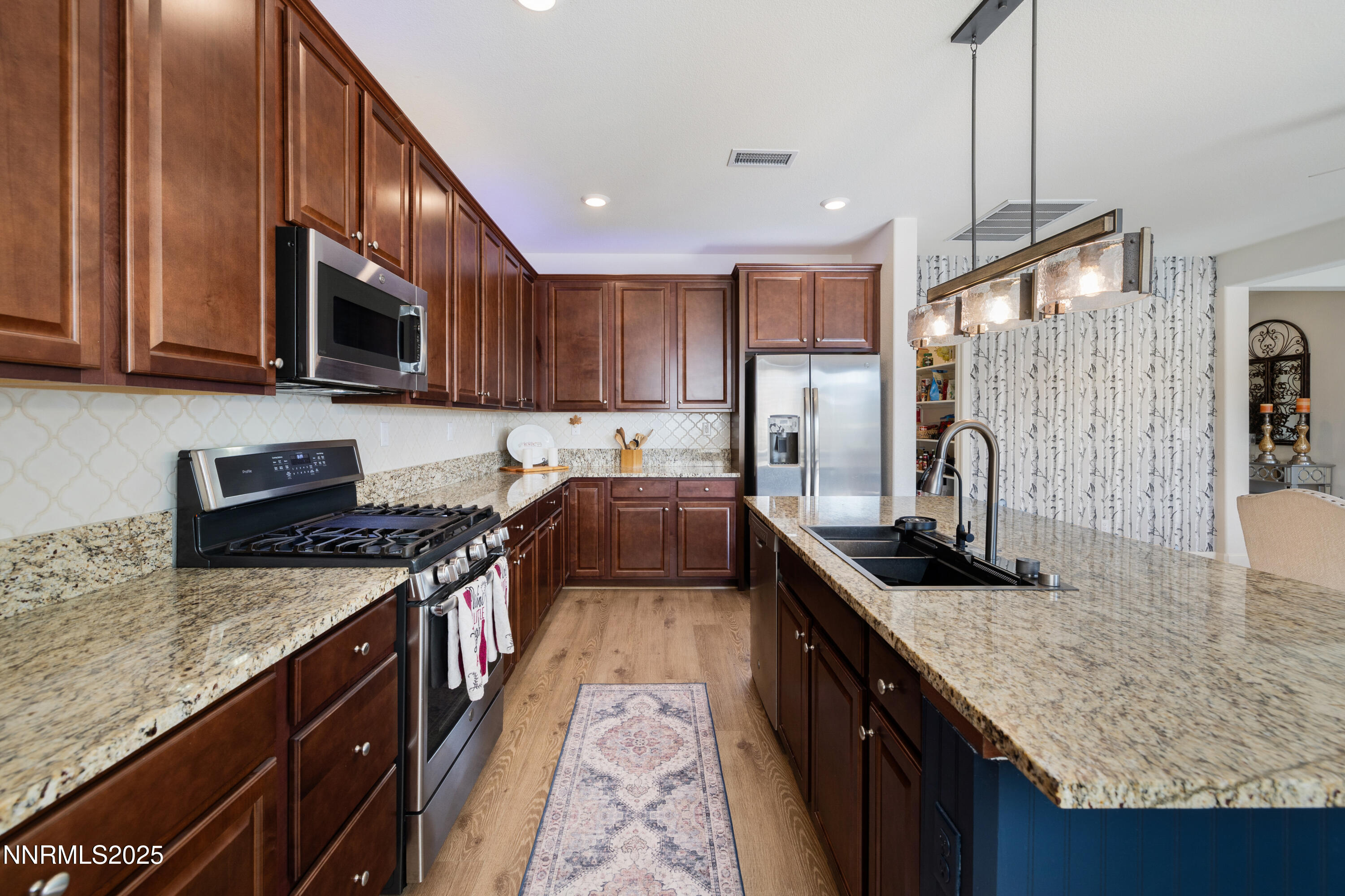 10260 Rollins Drive Reno, NV 89521 - Photo 12 of 44 a kitchen with granite countertop stainless steel appliances and wooden cabinets