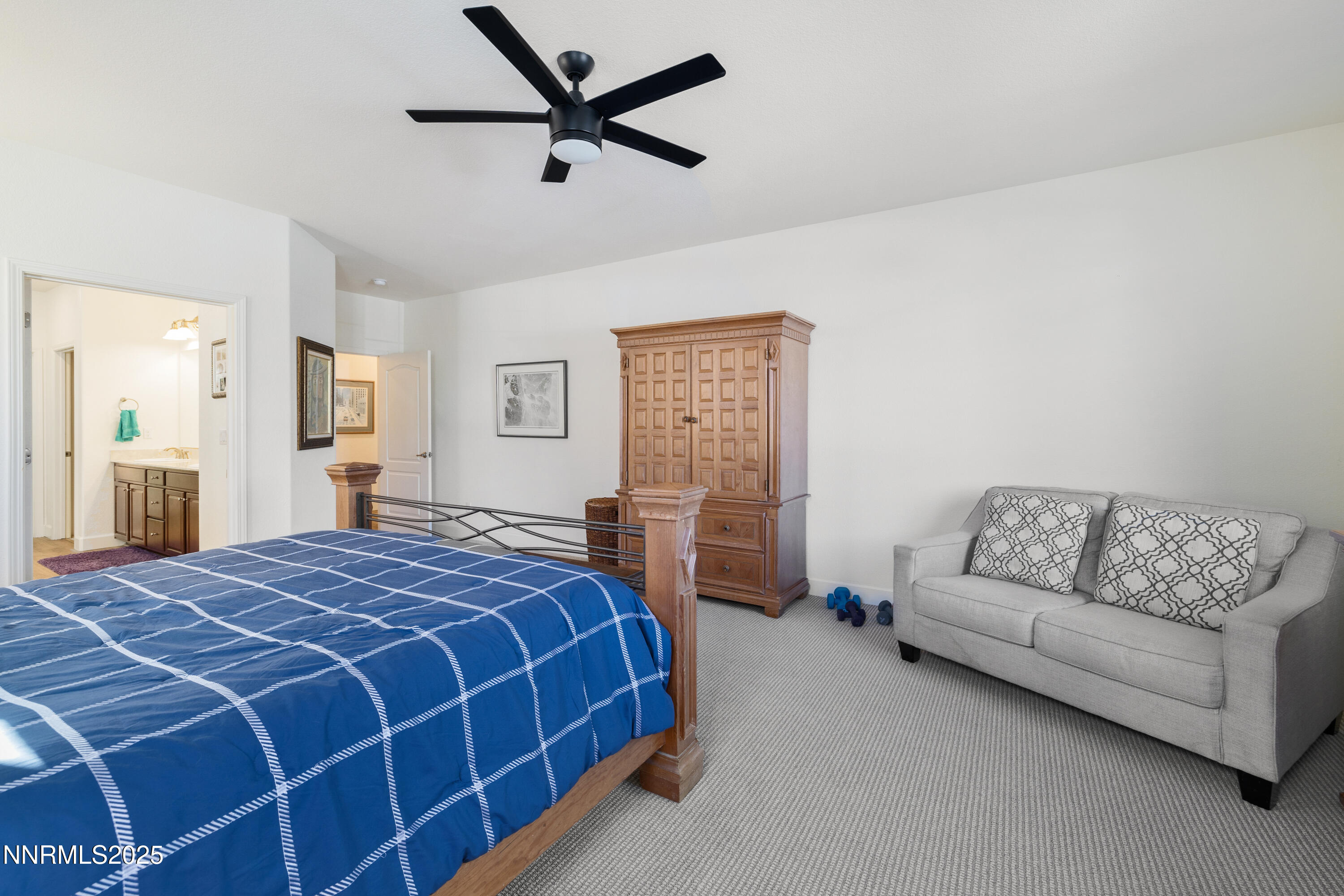 10260 Rollins Drive Reno, NV 89521 - Photo 18 of 44 a spacious bedroom with a bed a couch and a window