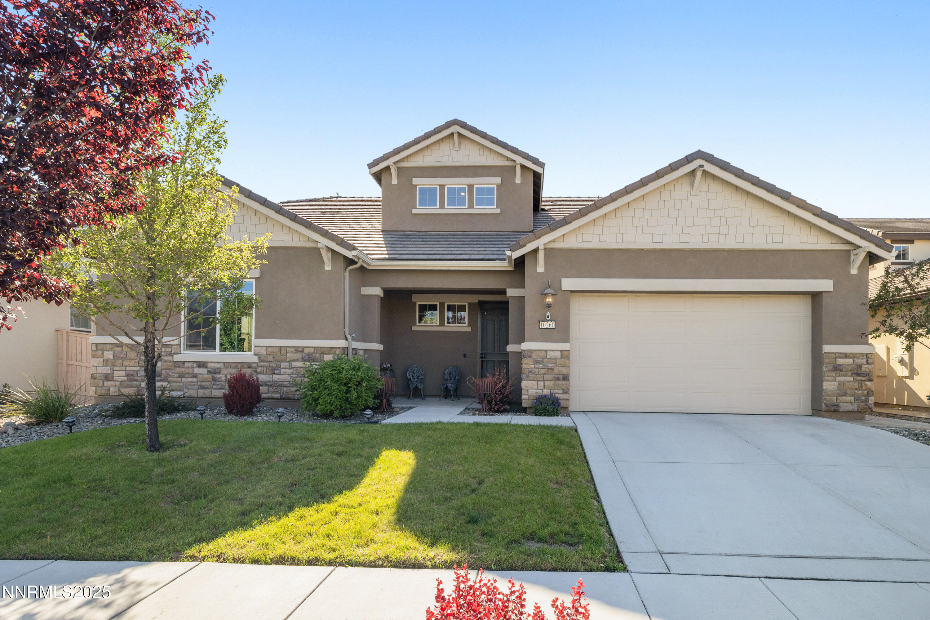 10260 Rollins Drive Reno, NV 89521 - Photo 2 of 44 a front view of a house with a yard and garage