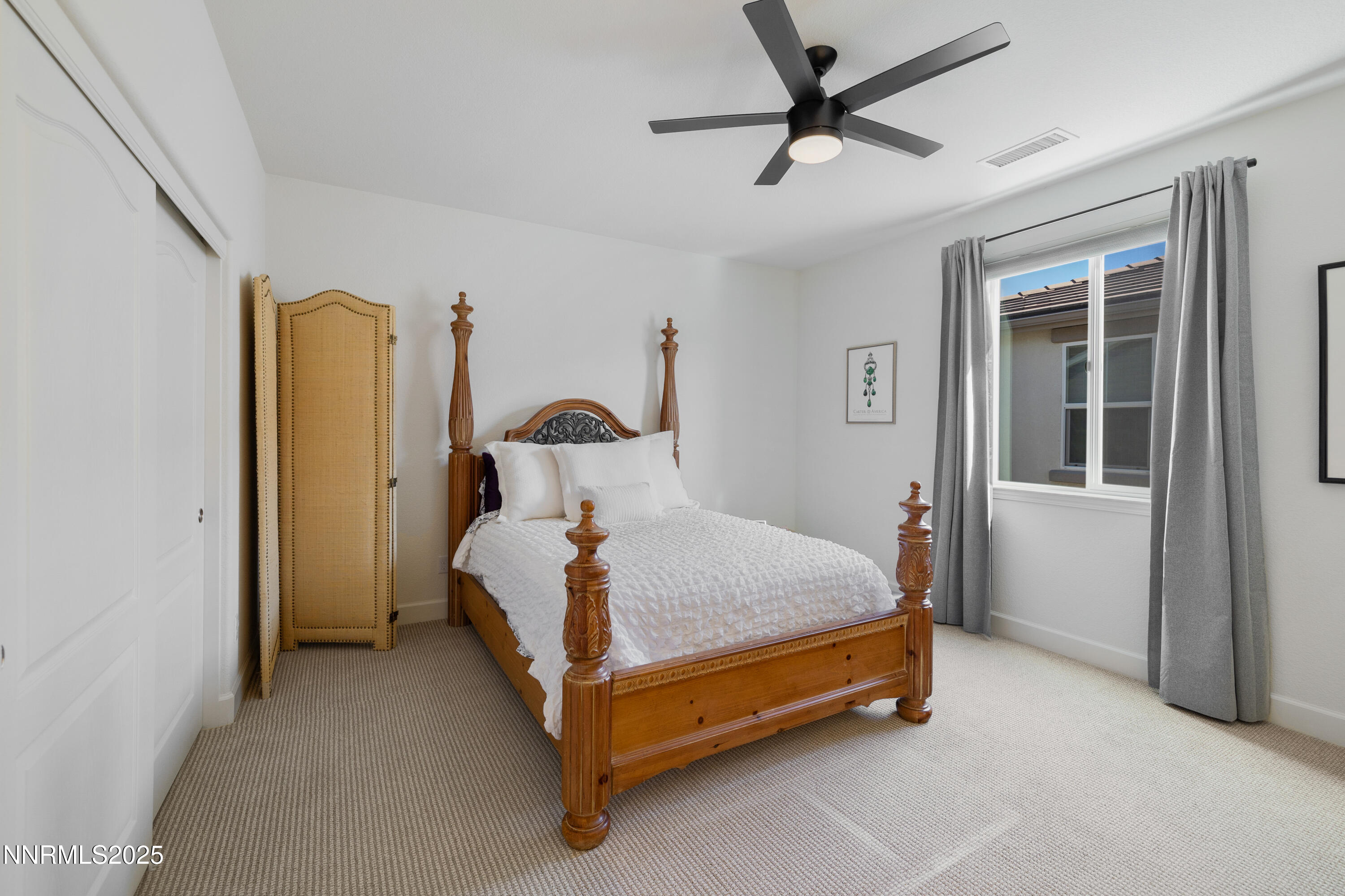 10260 Rollins Drive Reno, NV 89521 - Photo 27 of 44 a bed sitting in a bedroom next to a window and a chandelier