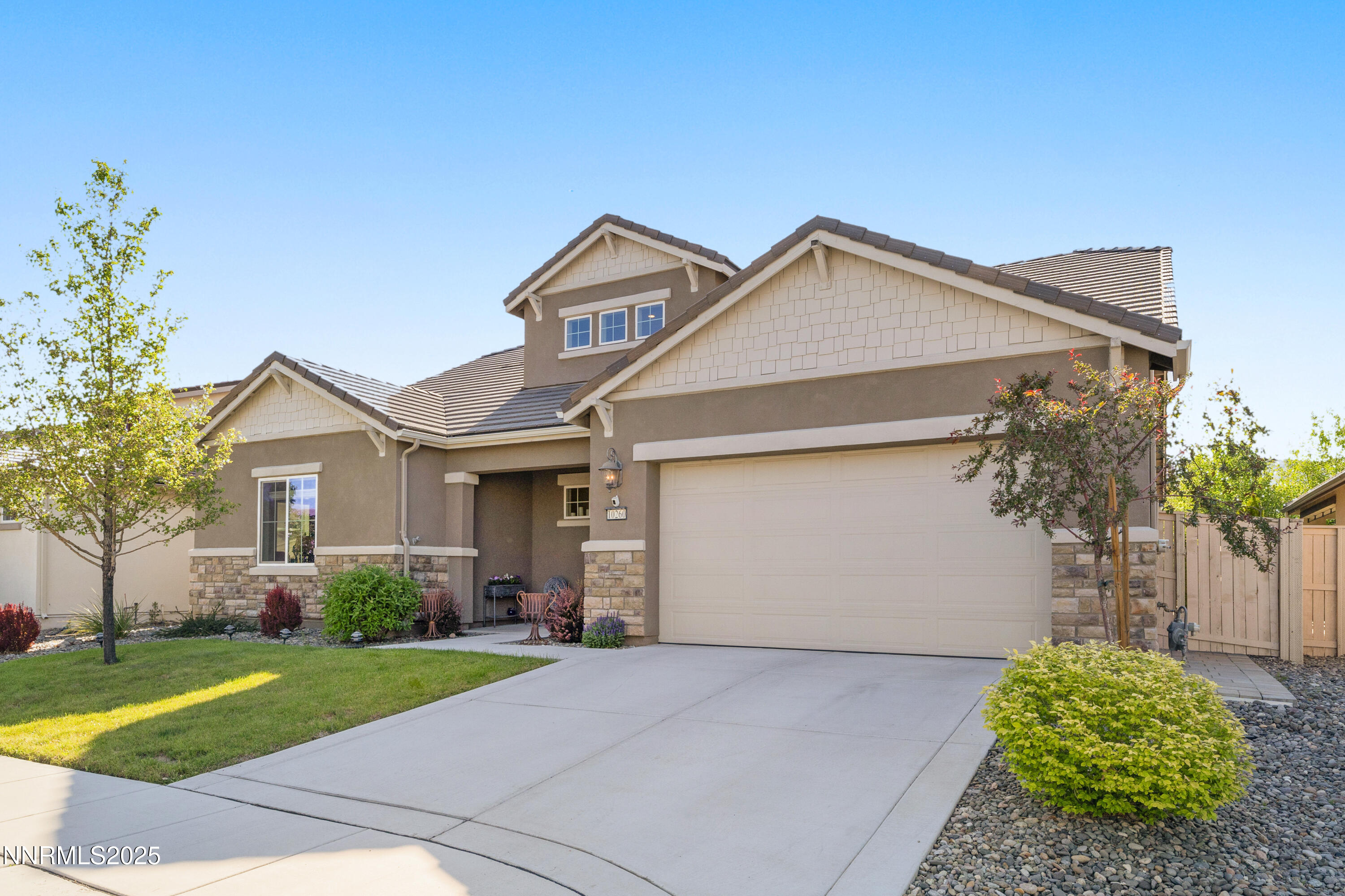 10260 Rollins Drive Reno, NV 89521 - Photo 4 of 44 a view of a white house next to a yard and a large trees