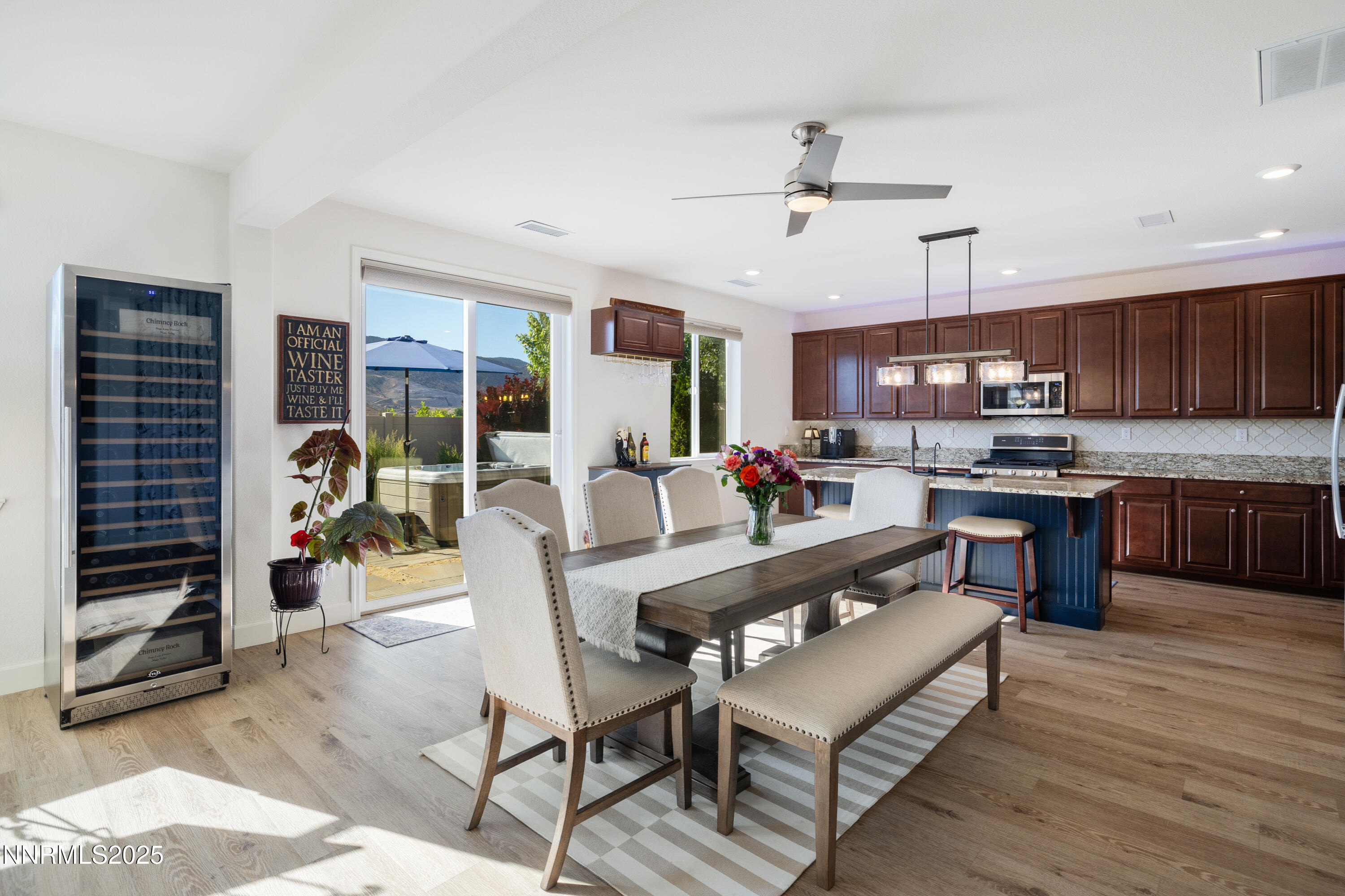 10260 Rollins Drive Reno, NV 89521 - Photo 8 of 44 a kitchen with stainless steel appliances kitchen island granite countertop a refrigerator a stove a sink a dining table and chairs with wooden floor