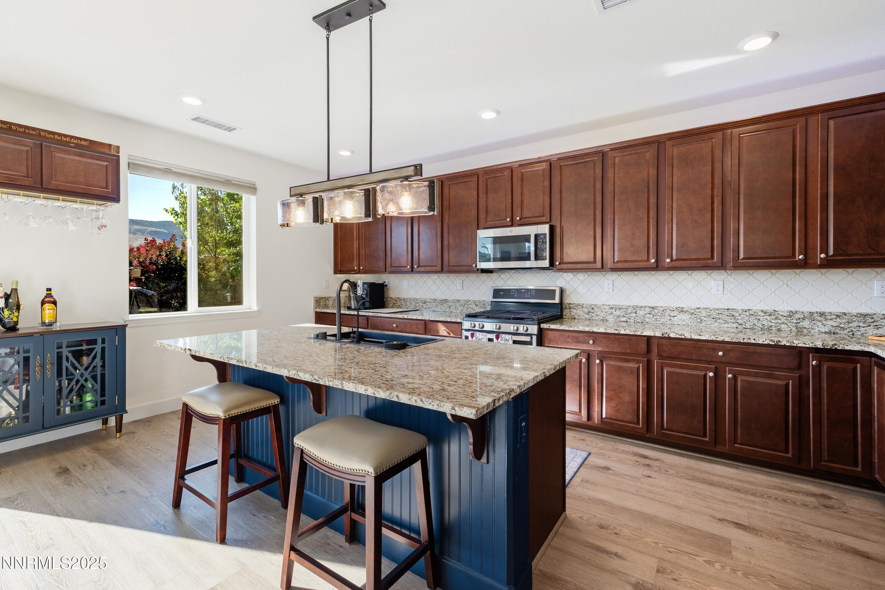 10260 Rollins Drive Reno, NV 89521 - Photo 10 of 44 a kitchen with a stove a sink a microwave a dining table and chairs