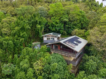 a view of a house with a backyard and trees