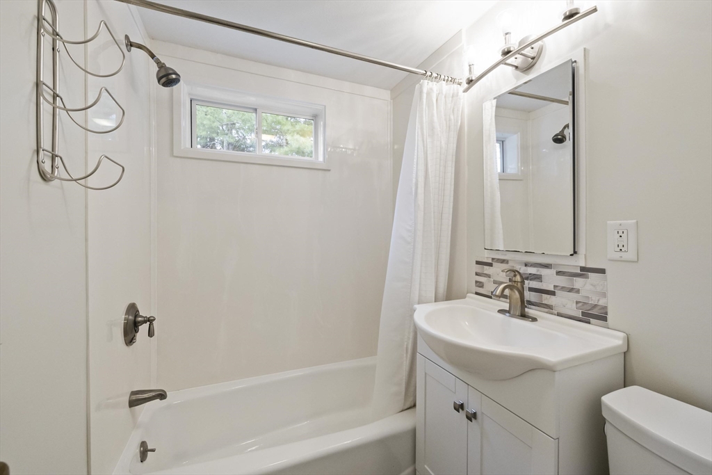 1652 Parker Street Springfield, MA 01128 - Photo 16 of 22 a bathroom with a sink a mirror a toilet and a bathtub