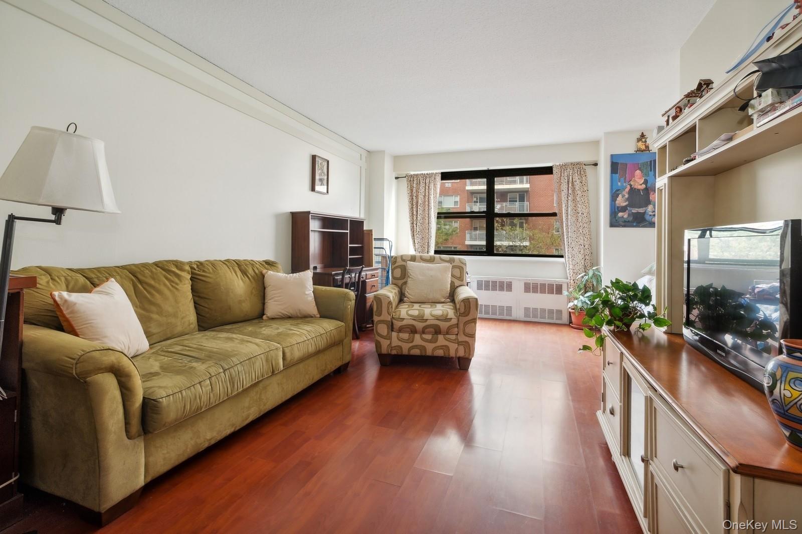 39-60 54th Street, Unit 3B Queens, NY 11377 - Photo 3 of 6 a living room with furniture flat screen tv and a large window
