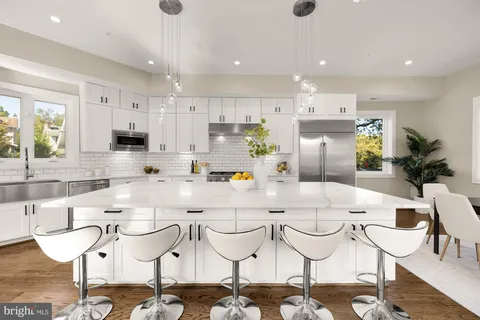 a kitchen with a dining table chairs cabinets and stainless steel appliances