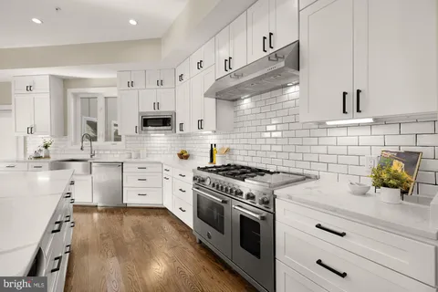 a kitchen with stainless steel appliances white cabinets and a stove
