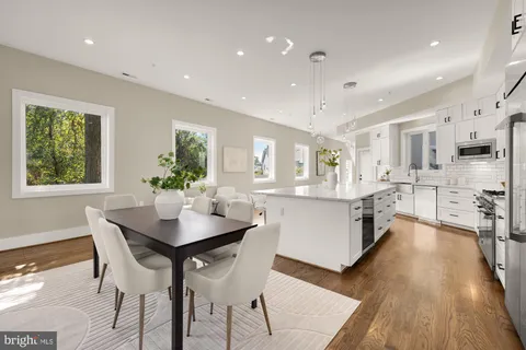 a living room with stainless steel appliances kitchen island granite countertop furniture and a wooden floor