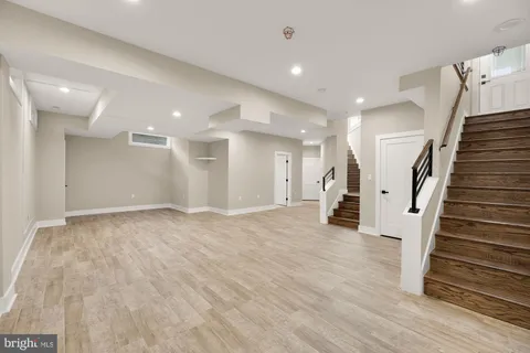 a view of a hallway with wooden floor and stairs