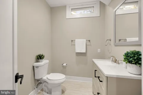 a bathroom with a sink mirror and toilet
