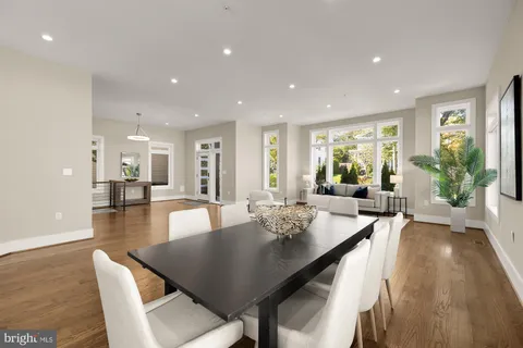 a view of a dining room and livingroom with furniture wooden floor a rug and a chandelier