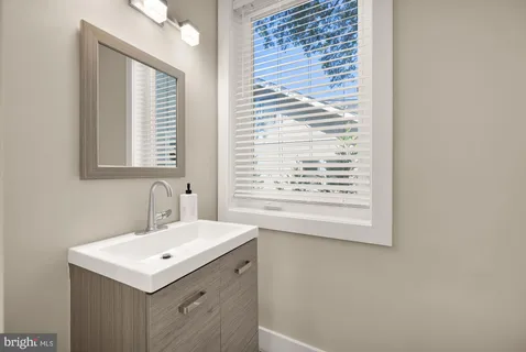 a bathroom with a sink a vanity and a window