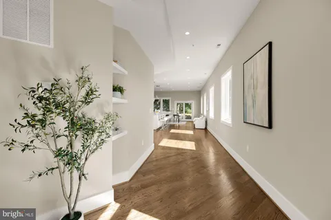 a view of a hallway with wooden floor and a potted plant