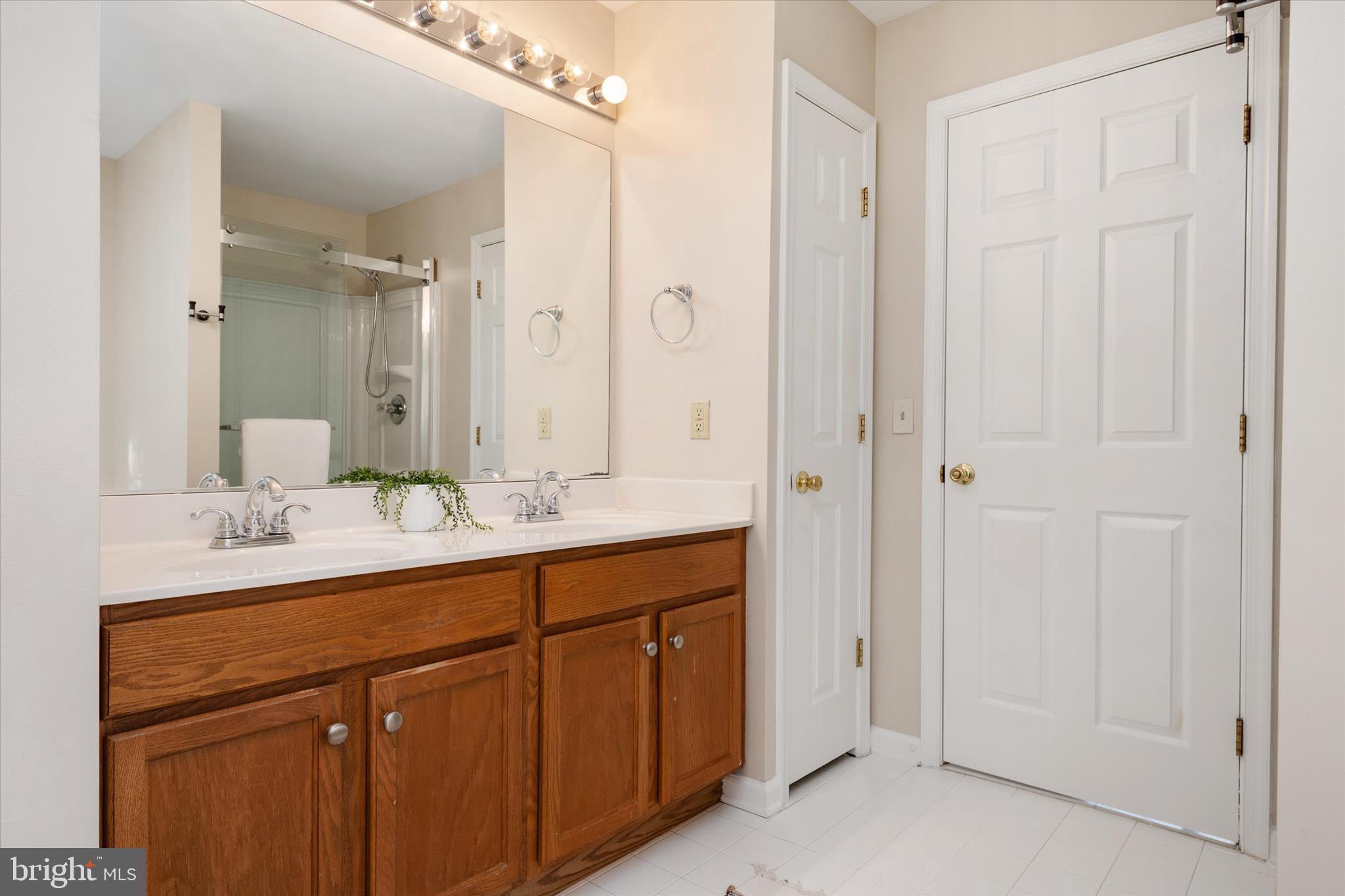 1409 Sweet Cherry Court Severn, MD 21144 - Photo 29 of 56 a bathroom with a double vanity sink and mirror