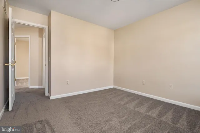 an empty room with windows and refrigerator