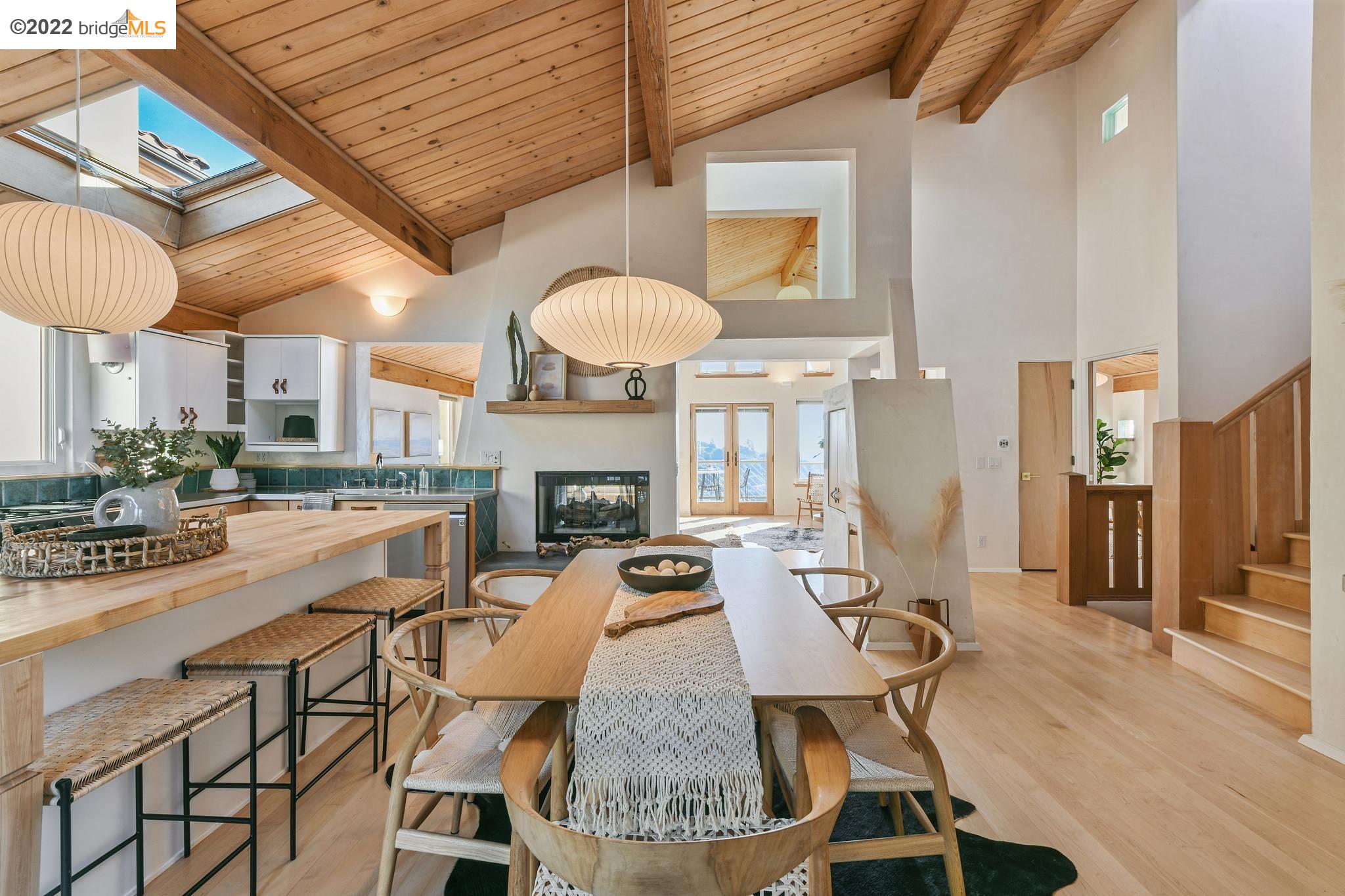 a view of a dining room with furniture a fireplace and wooden floor