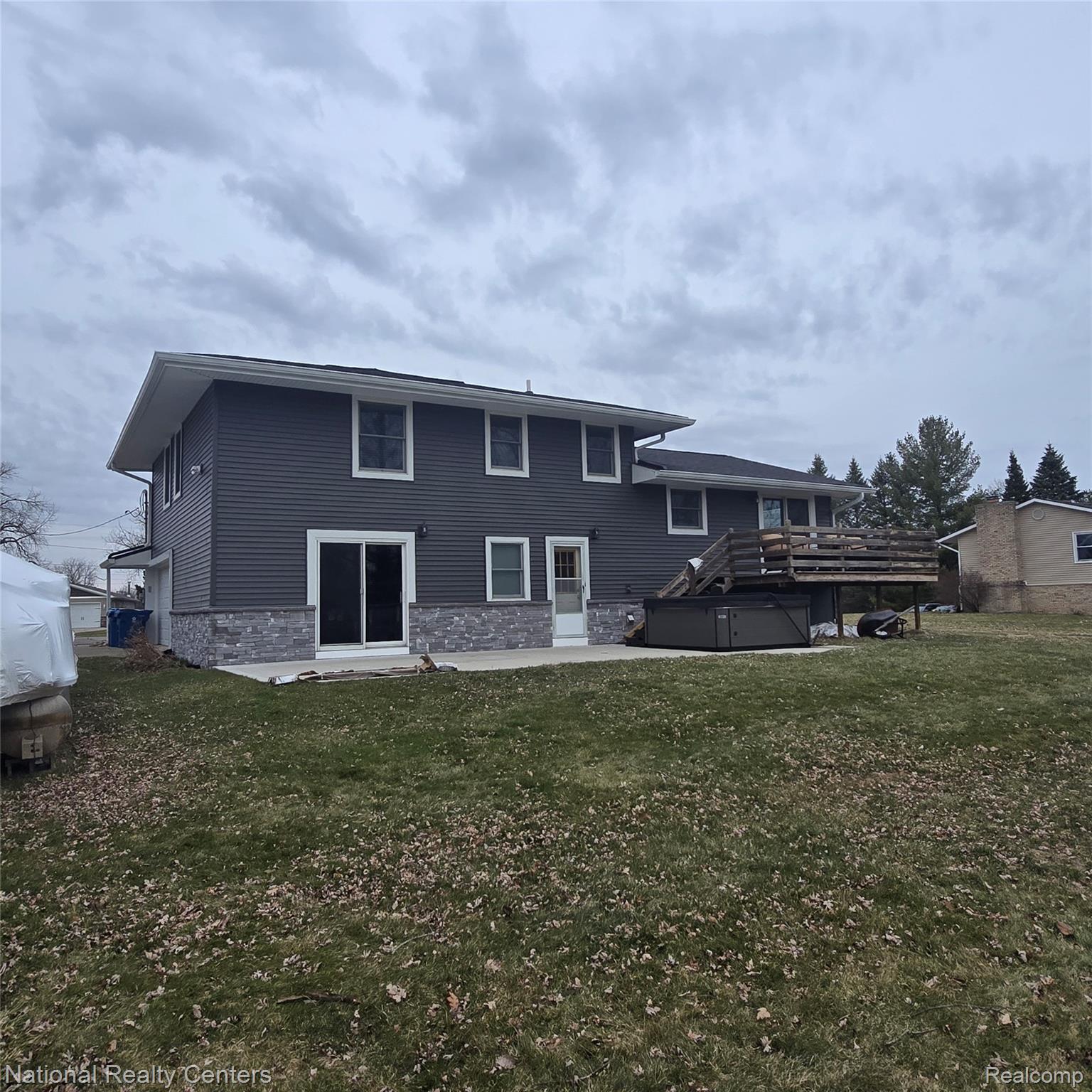 13477 South Horrell Road Fenton, MI 48430 - Photo 20 of 30 Back of house featuring stone siding, a lawn, and a deck