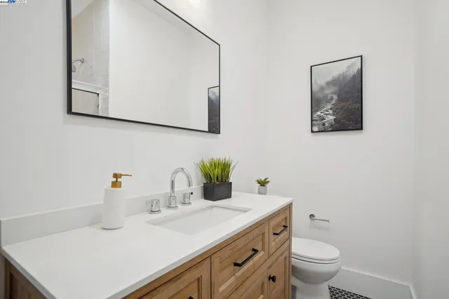 a bathroom with a sink a toilet and mirror