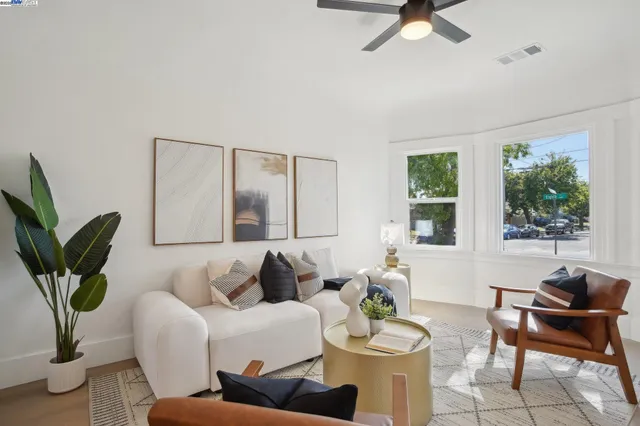 a living room with furniture a potted plant and a large window