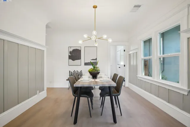 a dining room with furniture potted plants and wooden floor