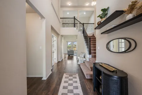 a view of a hallway with wooden floor and staircase