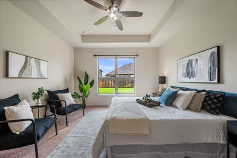 a bedroom with a bed a chandelier and a mirror on the dresser