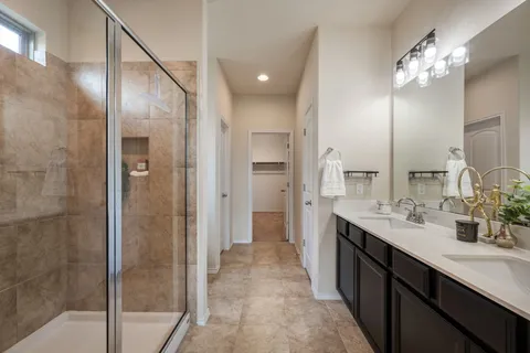 a bathroom with a double vanity sink mirror and shower