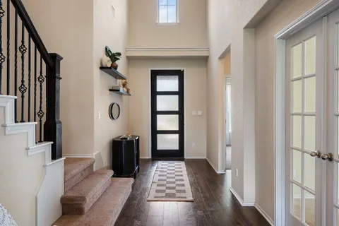 a living room with furniture a large window and wooden floor