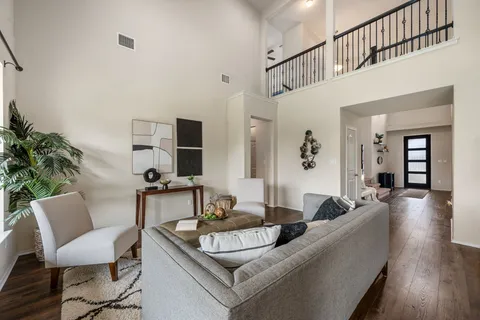 a living room with furniture kitchen view and a chandelier