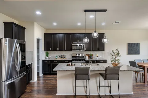 a kitchen with granite countertop stainless steel appliances a sink stove top oven and cabinets