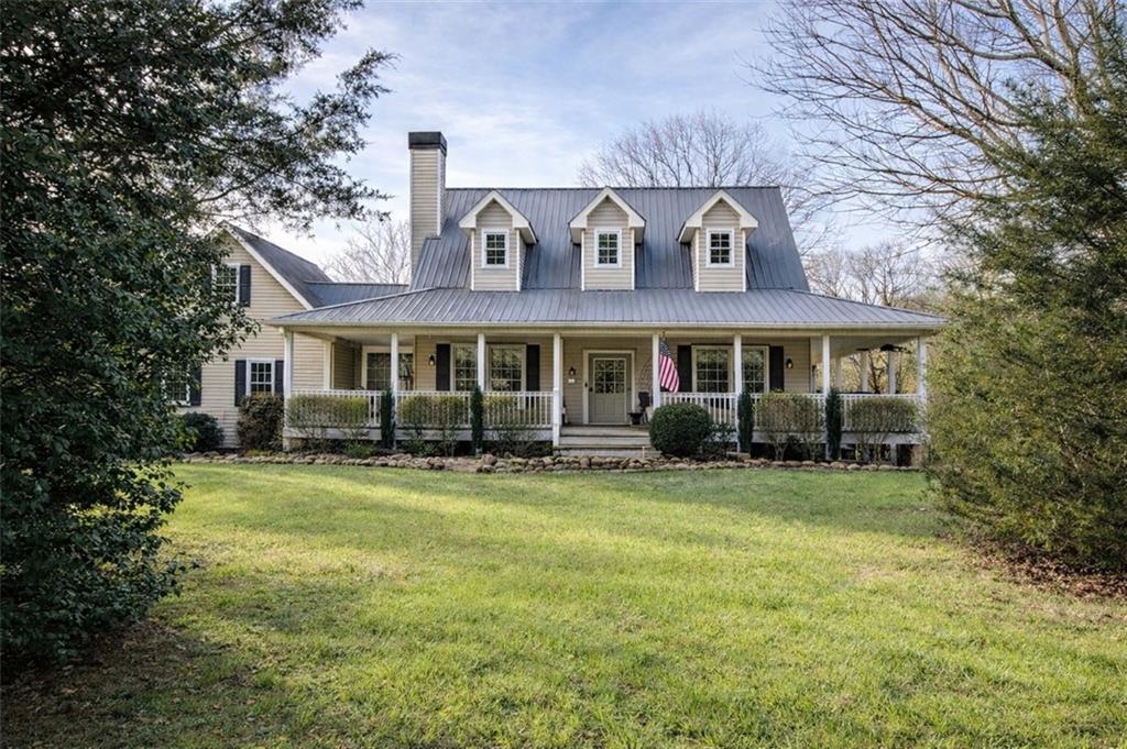 a view of a house with a yard and sitting area