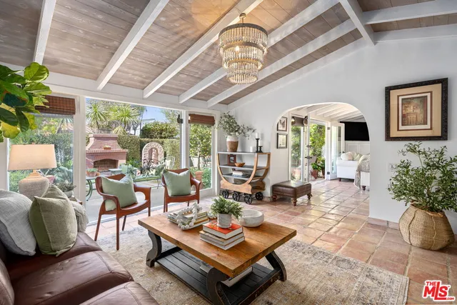 a living room with patio furniture and a chandelier
