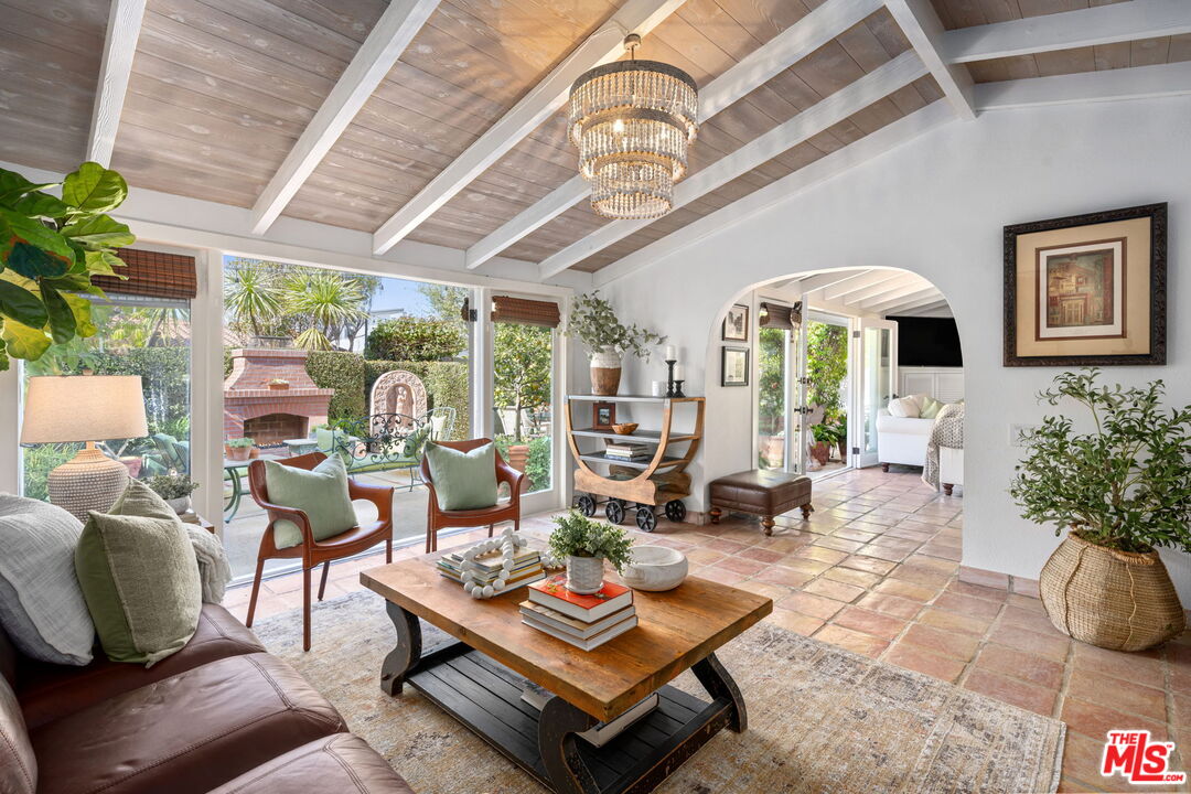 a living room with patio furniture and a chandelier