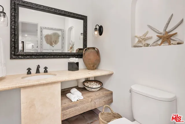 a bathroom with a toilet a sink and a mirror