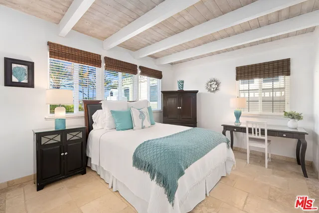 a bedroom with a bed and a table chair in it