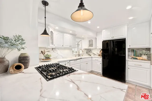 a kitchen with stainless steel appliances granite countertop a sink a stove and refrigerator