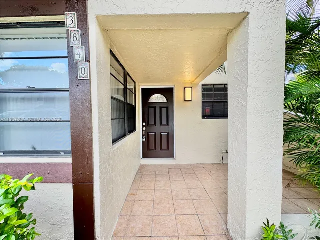 a view of a hallway with wooden floor and a potted plant