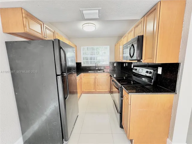 a kitchen with a refrigerator and a sink