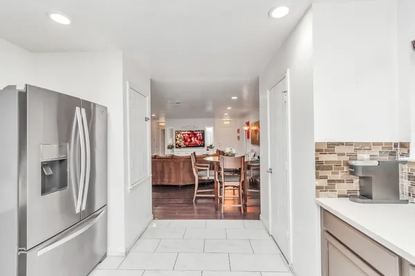 a view of a kitchen with furniture and a refrigerator