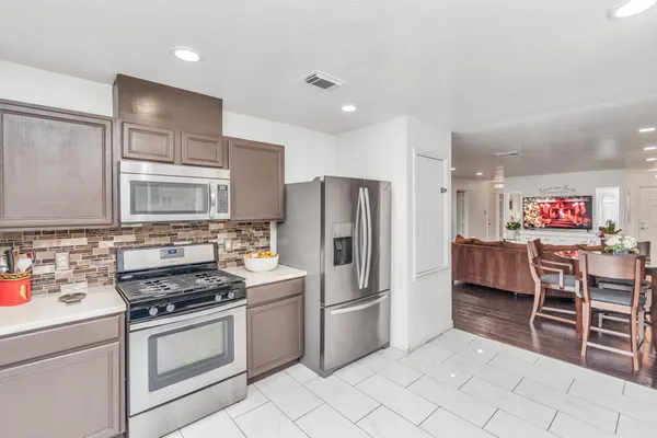 a kitchen with stainless steel appliances a stove a sink and a refrigerator