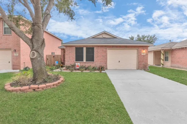 a front view of a house with a garden and yard