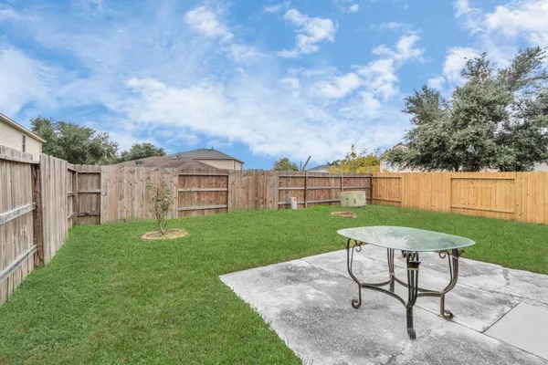 a view of a backyard with table and chairs and a yard