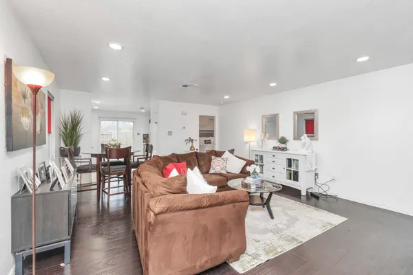 a living room with furniture and a dining table with kitchen view