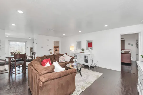 a living room with furniture and a wooden floor