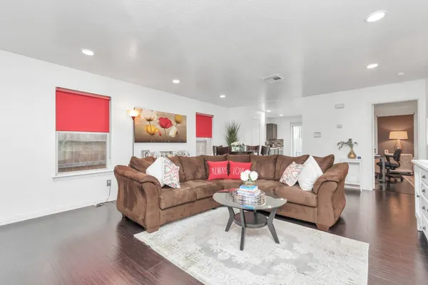 a living room with furniture and wooden floor