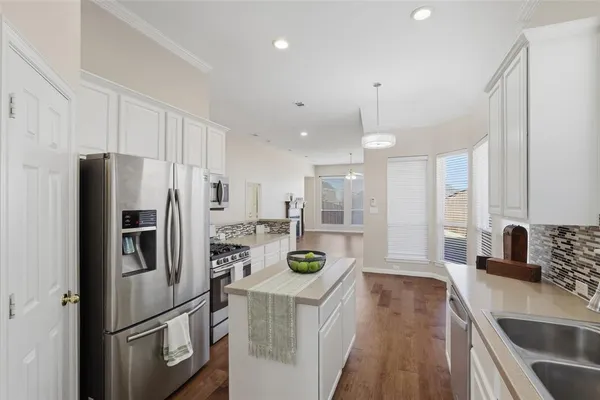 a kitchen with stainless steel appliances a refrigerator sink and stove