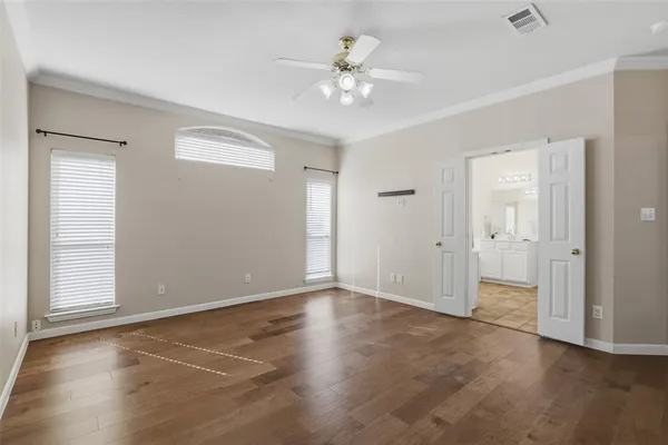 an empty room with fan and windows