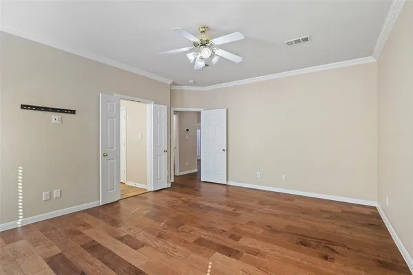 a view of an empty room with wooden floor
